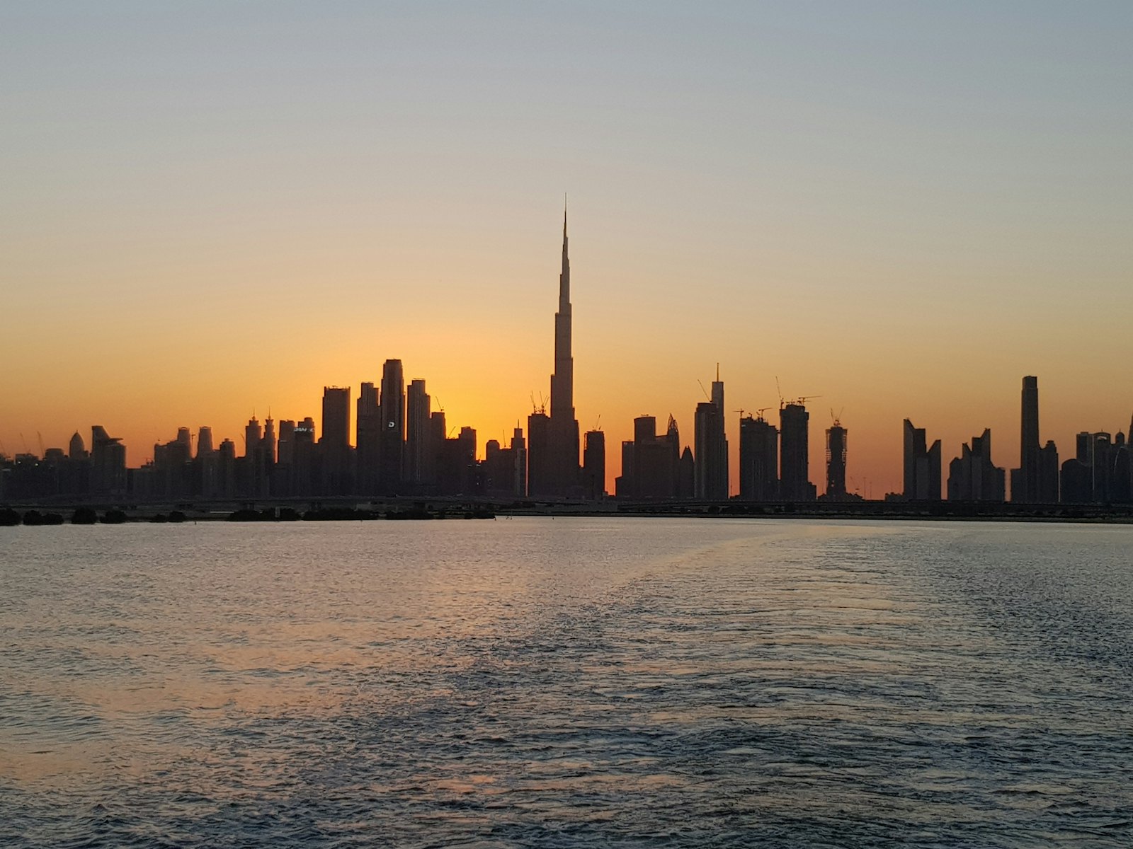 Dubai skyline at sunset seen across the water